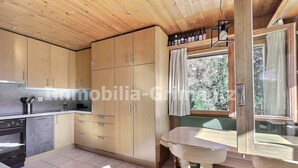 A kitchen with wooden cabinets, a sink, and a window with curtains.