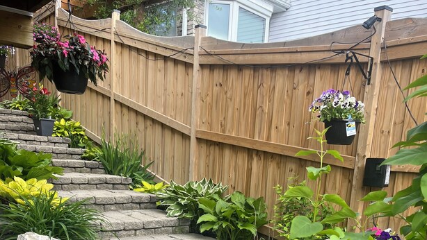 A stone staircase leading up to a wooden deck, surrounded by various plants and flowers. - Detached home with heated saltwater pool 45 minutes from Toronto (Whitby)