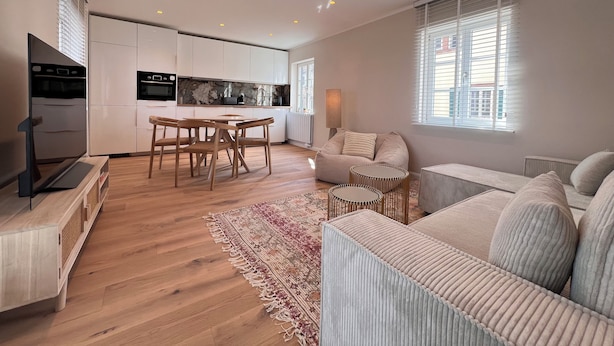 A modern apartment with a kitchen, dining area, and living room.