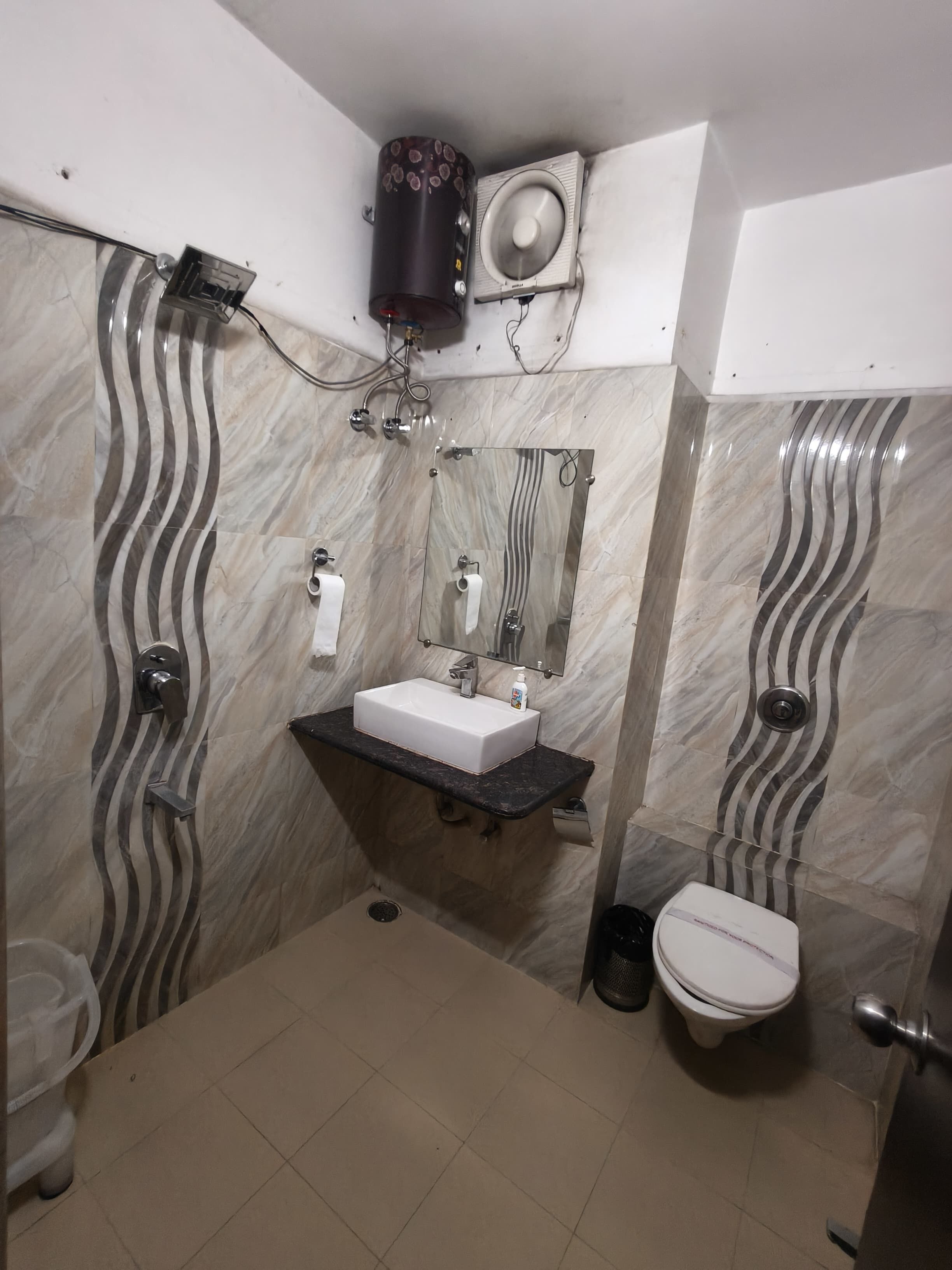 A bathroom with a white sink, mirror, toilet, and shower.