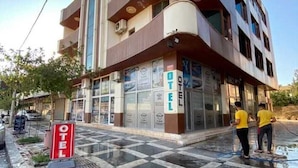 A hotel with a modern design, featuring a prominent 'OTEL' sign, large windows, and a checkered floor pattern. - Hotel El Muhtar (Akcakale)