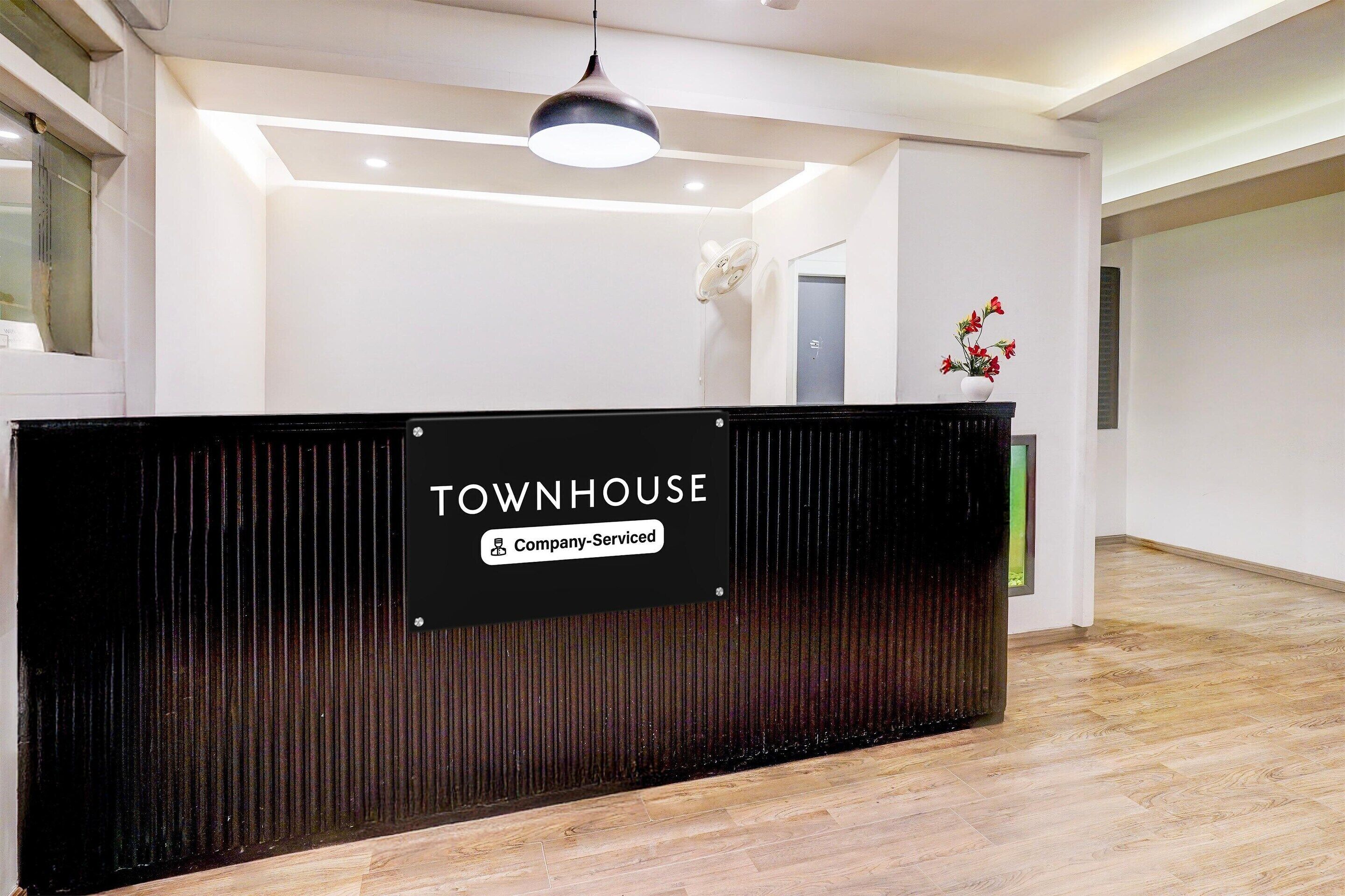 A reception desk with a sign that reads 'TOWNHOUSE Company-Serviced.'