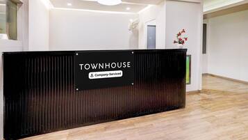 A reception desk with a sign that reads 'TOWNHOUSE Company-Serviced.'