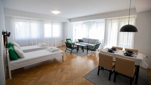 Een moderne woonkamer met een bank, een eettafel voor vier personen en een salontafel.