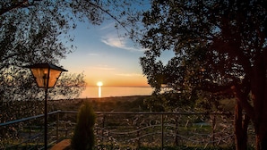A sunset view with a lamp post and a metal fence in a park setting. - Il Giardino dei Filosofi (Ascea)