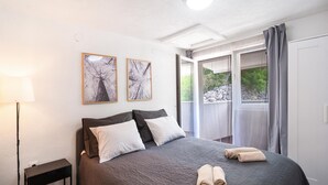 A bedroom with a bed, two pillows, a bedside table, a lamp, and two framed pictures on the wall. - Cozy home in Podosoje (Podosoje)
