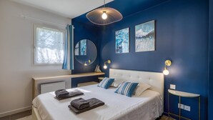 A bedroom with a large bed, a bedside table, a mirror, and artwork on the wall. - Awesome home in Dolus-d'Oléron with sauna (Dolus-d'Oléron)