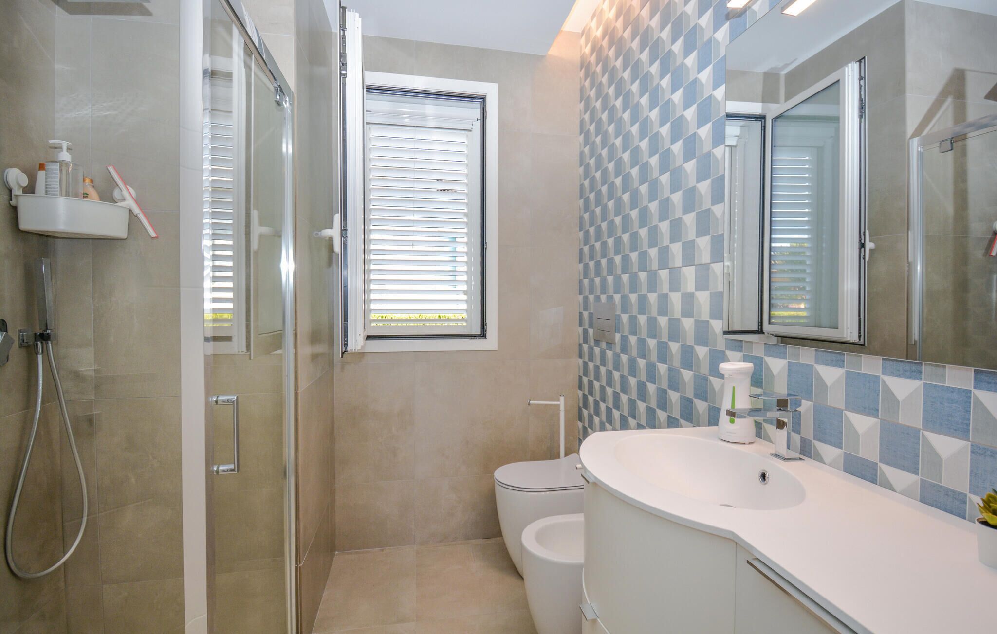 Ein Badezimmer mit Dusche, Toilette und Waschbecken.