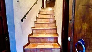 A staircase with a handrail leading to a door with a blue handle. - Casa Gioia - Casa Olivieri  (Pienza)