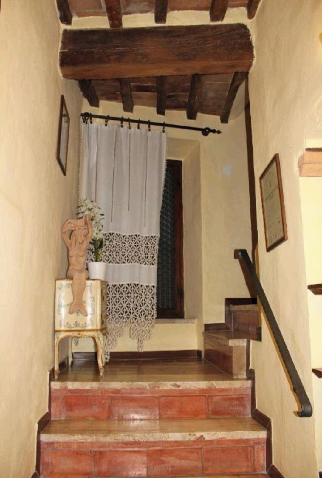Eine Treppe mit Holzbodenstufen und einem weißen Vorhang.