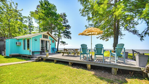 A turquoise cabin with a deck, picnic table, and chairs, overlooking a body of water. - Tiny House w/ Big Views: Cabin in Shiloh! (Shiloh)