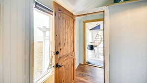 A wooden door leading to a room with a view of a patio area. - Tiny House w/ Big Views: Cabin in Shiloh! (Shiloh)