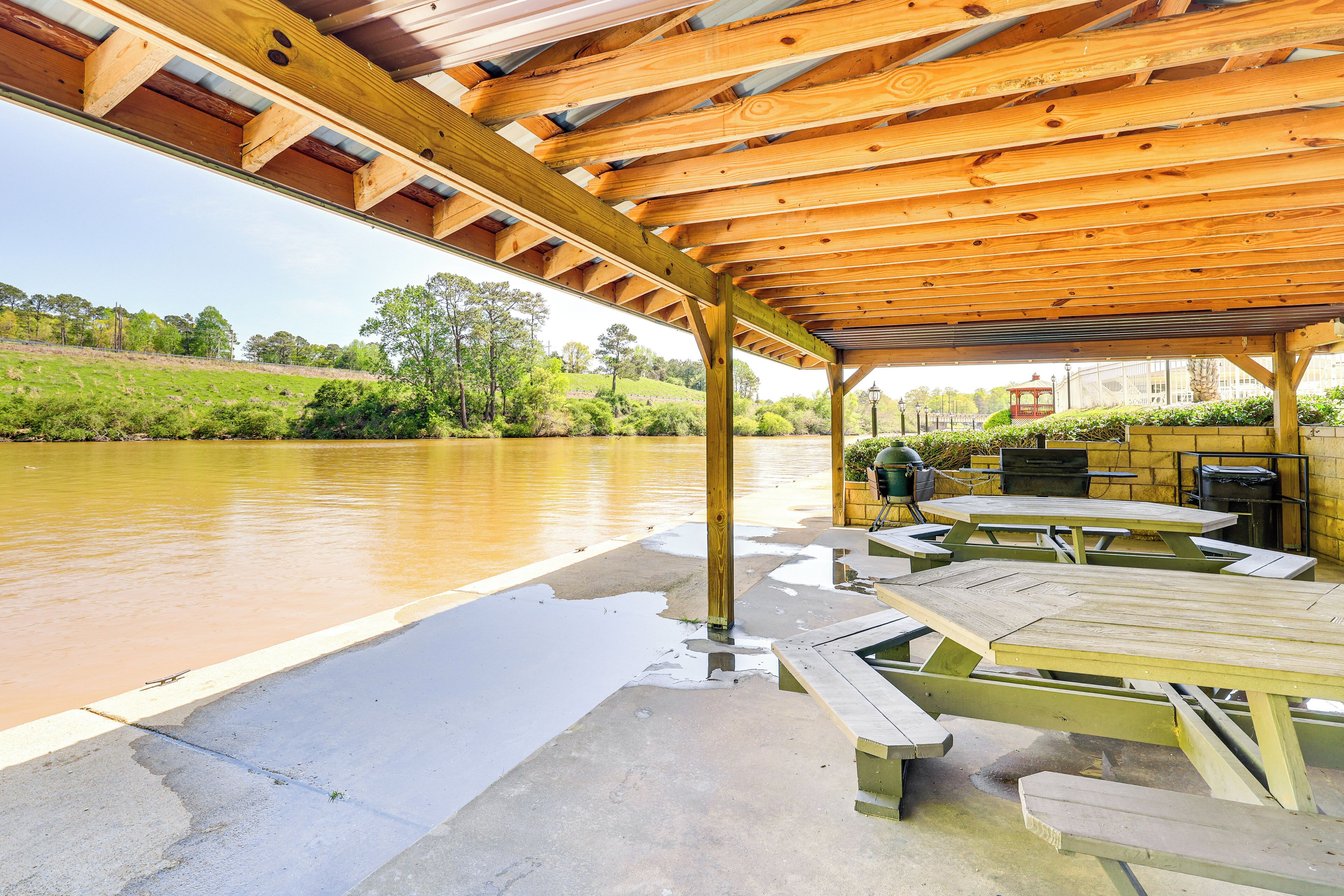 A covered picnic area with picnic tables and a view of a river.