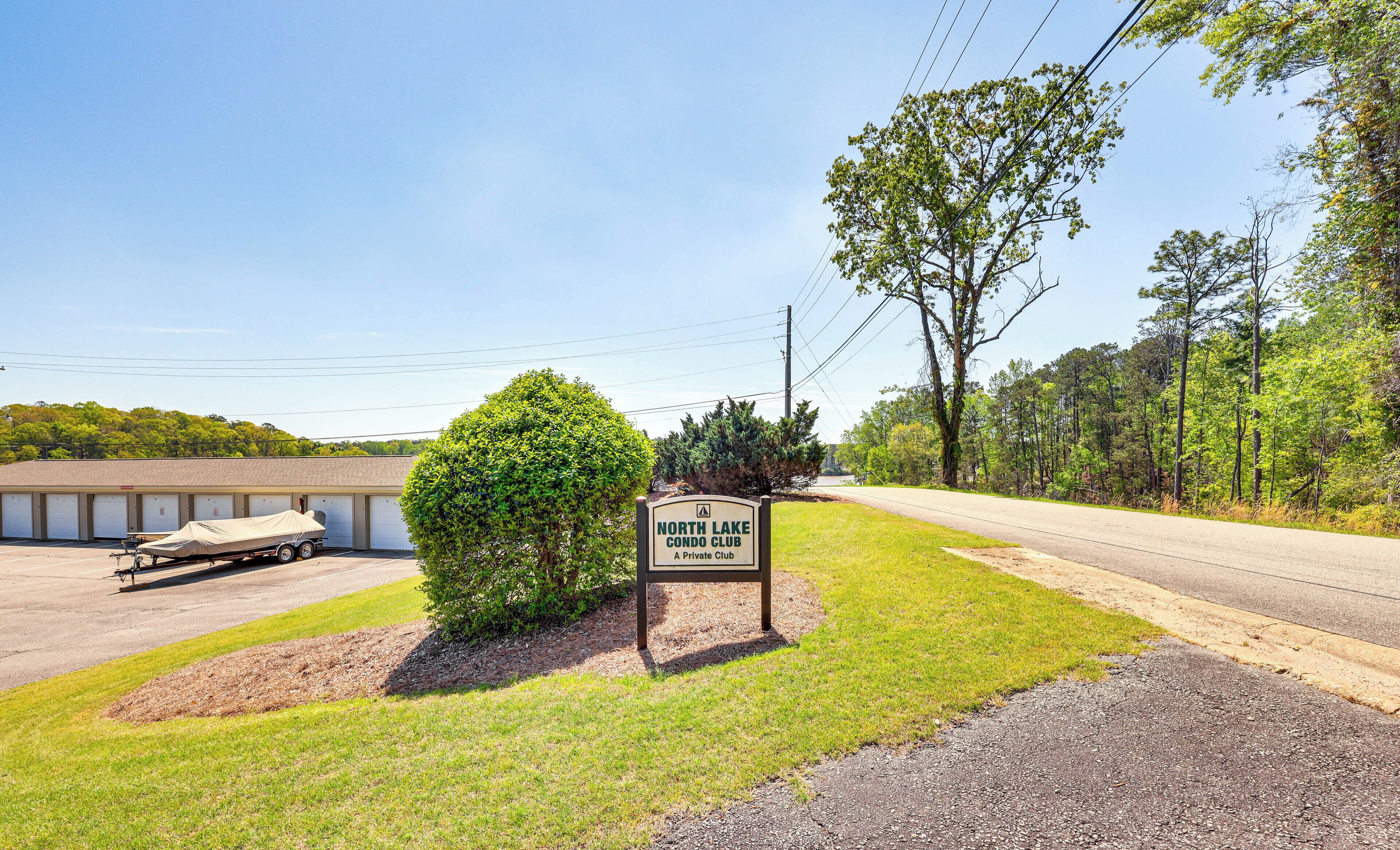 A North Lake Condo Club sign, a parking lot, a covered trailer, and a building with a garage.
