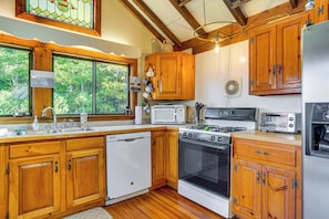 A kitchen with wooden cabinets, a dishwasher, a stove, and a microwave.