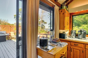 A kitchen with a large window, wooden cabinets, and a countertop with kitchen appliances.