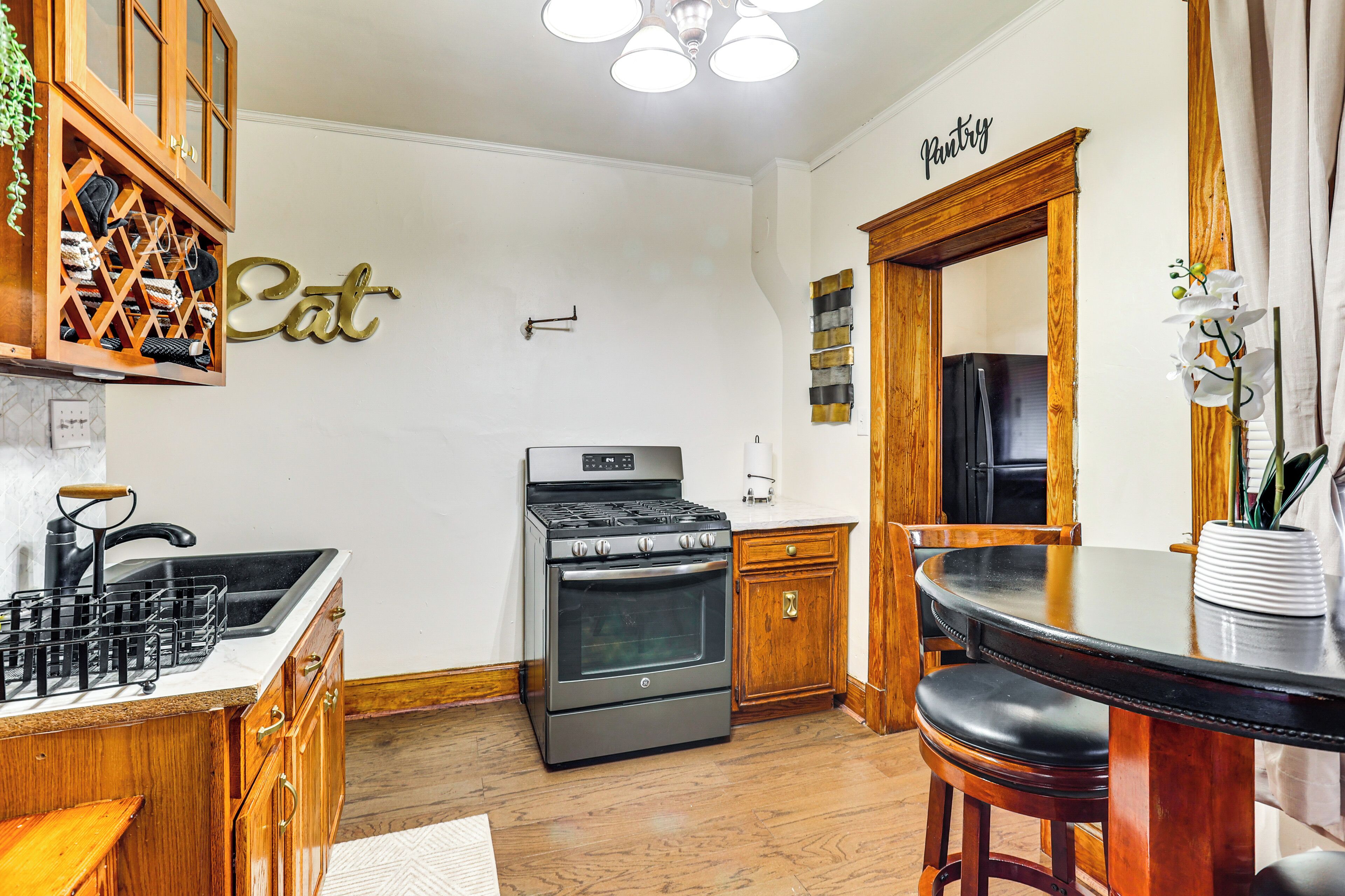A kitchen with wooden cabinets, a stove, and a dining table with chairs.