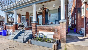 A two-story brick house with a front porch, a small garden, and a visible staircase leading to the entrance. - 2 Mi to Dtwn: Harrisburg Escape w/ Furnished Deck! (Harrisburg)