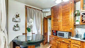 A kitchen with wooden cabinets, a microwave, and a dining table with chairs. - 2 Mi to Dtwn: Harrisburg Escape w/ Furnished Deck! (Harrisburg)