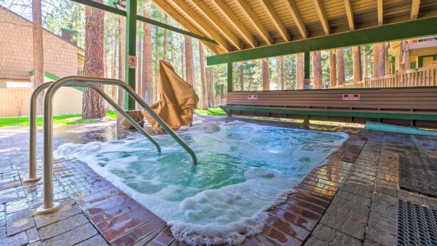 A hot tub area with a wooden deck, metal ladder, and a no smoking sign. - Walk to Shops & Eats: Mammoth Lakes Condo w/ Pool (Mammoth Lakes)