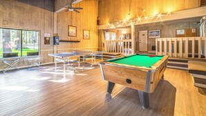 A pool table in a room with wooden walls and ceiling, a ceiling fan, and a window with a view of greenery. - Walk to Shops & Eats: Mammoth Lakes Condo w/ Pool (Mammoth Lakes)