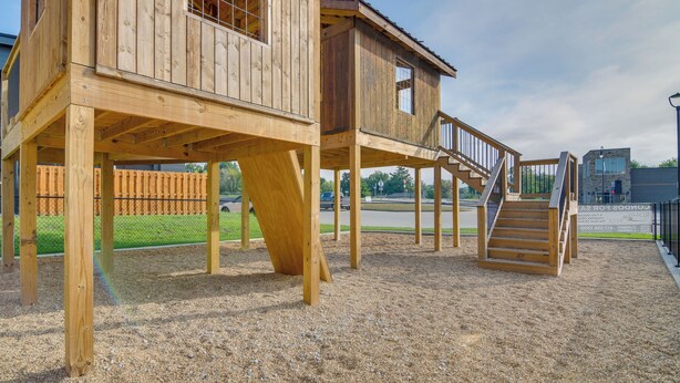 Une structure de jeu en bois comportant plusieurs niveaux et un escalier.