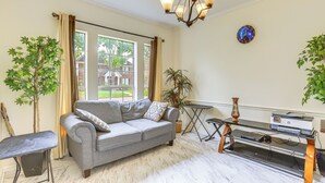 A living room with a grey sofa, a small table with a vase, and a plant. - Home 7 Mi to Energy Corridor: Remote-work Ready! (Houston)