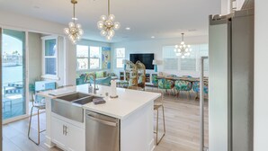 A modern kitchen with a central island, stainless steel appliances, and pendant lighting.