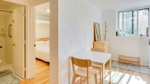 Une pièce avec un lit, une table et une fenêtre.