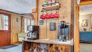 A rustic coffee bar with a coffee machine, mugs, and a sign that reads "This place is love, laughter, and strong coffee." - 2 Mi to Ossipee Lake: Forest-view Sanctuary! (Freedom)