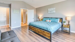 A bedroom with a bed, a ceiling fan, a nightstand, and a door leading to another room. - Outdoor Entertaining Space: Family Home in Milton (Milton)