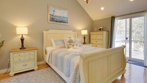 A bedroom with a bed, two bedside tables, a dresser, a painting, and a large window. - 1 Mi to South Village Beach: Bbq-ready Retreat (West Dennis)