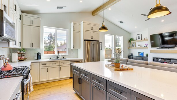 A modern kitchen with a large island, stainless steel appliances, and a dining area with a sofa. - Patio + Outdoor Dining: Modern Home in Paradise (Paradise)