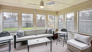 Et solrum med sofa, bord og stol.
