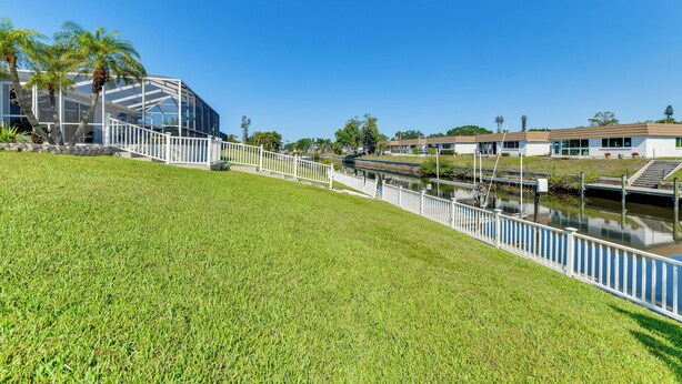 A modern building with a glass facade, a grassy area, and a water canal. - Waterfront Retreat w/ Pool & Yard in Sarasota (Sarasota)