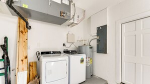 A laundry room with two stacked washers and dryers, a water heater, and a utility box. - Waterfront Retreat w/ Pool & Yard in Sarasota (Sarasota)
