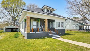 A single-story house with a front porch, a covered patio, and a small front yard.