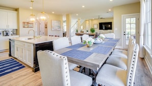A spacious kitchen with a large island, white cabinetry, and a blue rug. - Near Beach & Trails: Elegant Home in Cape Charles! (Cape Charles)