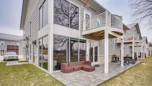 Una casa moderna de dos pisos con un porche cubierto, ventanas amplias y un balcón.