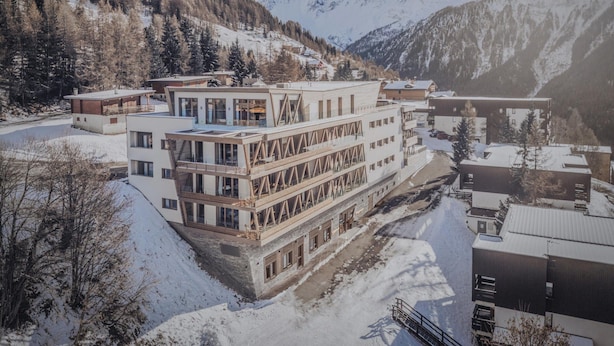 Un bâtiment moderne à plusieurs étages, doté de grandes fenêtres et d’un balcon.