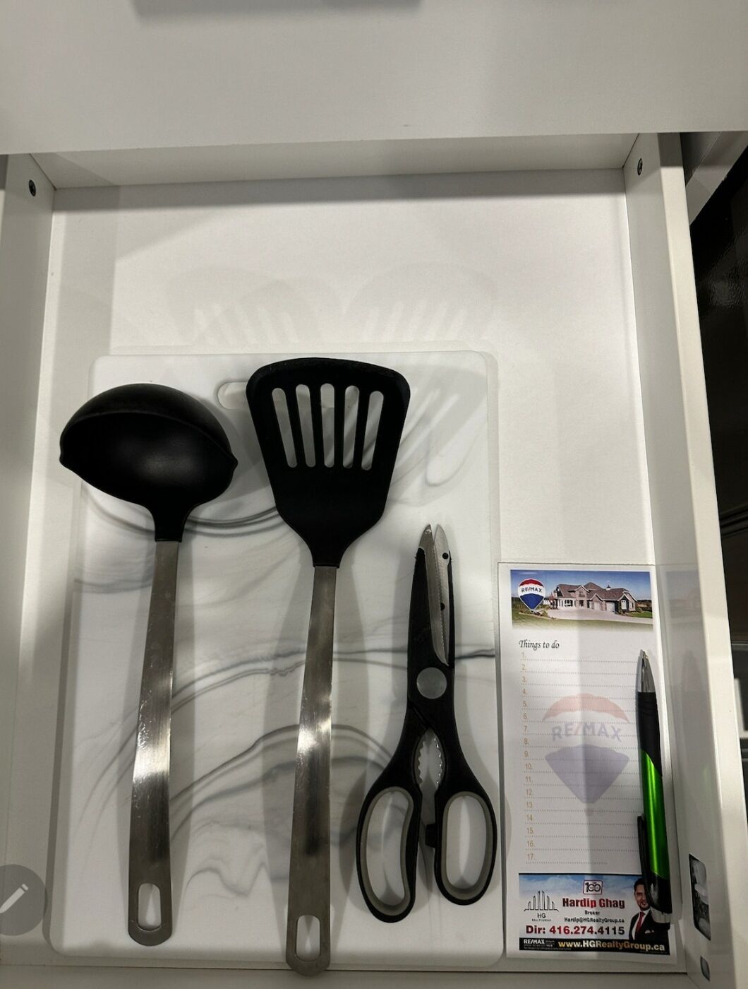 Een keukublade met een spatel, opscheplepel en schaar.