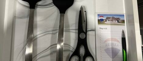 Een keukublade met een spatel, opscheplepel en schaar.