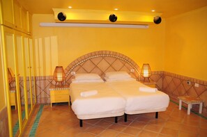 A hotel room with a large bed, two bedside tables, a small stool, and a mirror. - Spacious 5-bedroom villa in First line location, stunning views, Total privacy (Callao Salvaje)