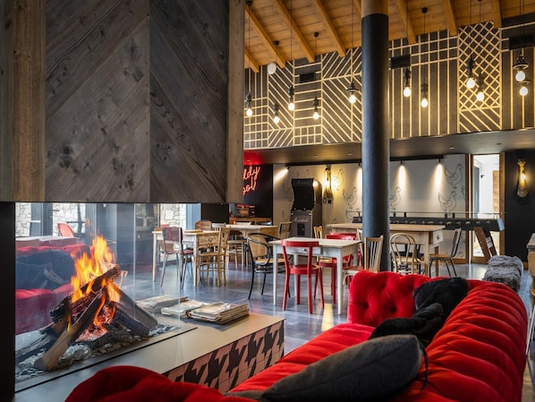 Een knus interieur met een open haard, houten vloeren en een moderne zithoek.