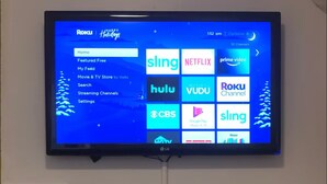 A television mounted above a fireplace displaying various streaming services. - Cozy Modern City Escape (Schenectady)