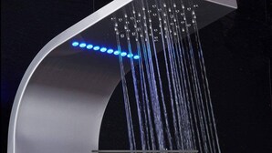 A modern shower with a curved design and multiple water jets. - Cozy Modern City Escape (Schenectady)