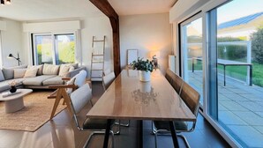 A modern living room with a wooden dining table, a sofa, and a ladder. - Holiday Home in Wenduine Near Zeedijk (De Haan)