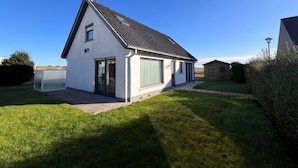 A single-story house with a sloped roof, a front door, and a garage. - Holiday Home in Wenduine Near Zeedijk (De Haan)