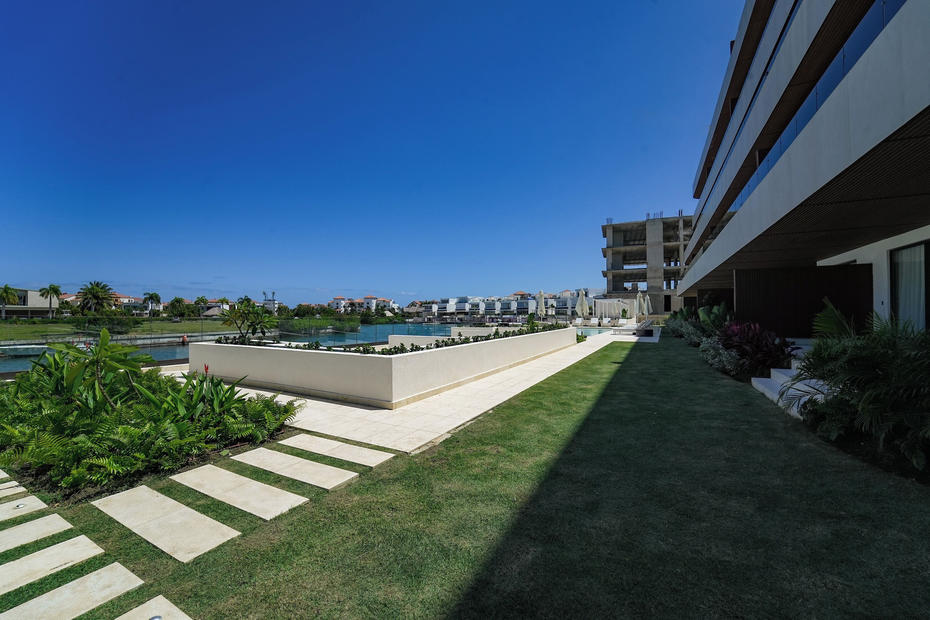 Un hôtel moderne doté d’une piscine, d’une pelouse bien entretenue et offrant une vue dégagée sur les bâtiments environnants.