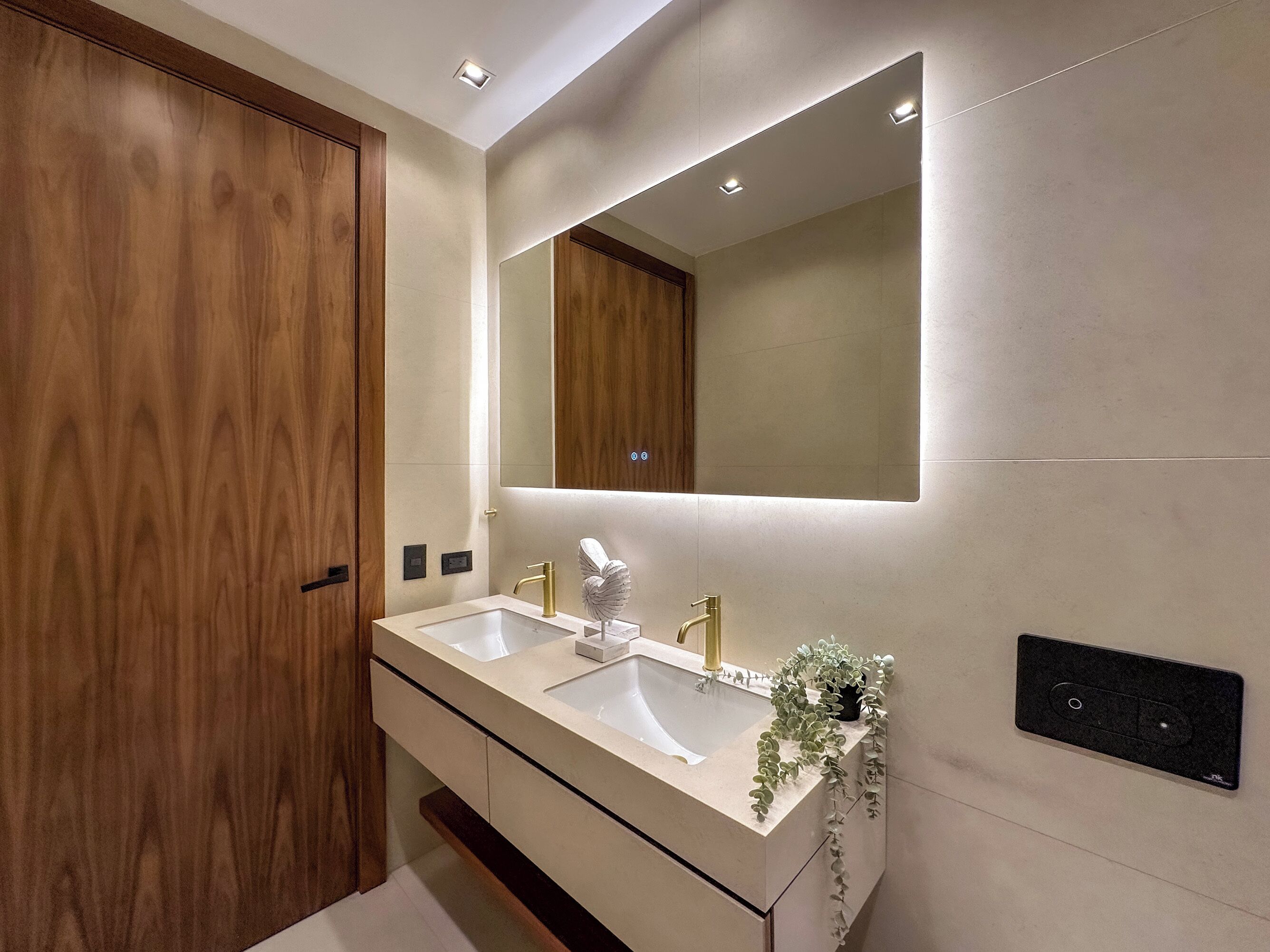 A modern bathroom with a double sink, wooden vanity, and a large mirror.